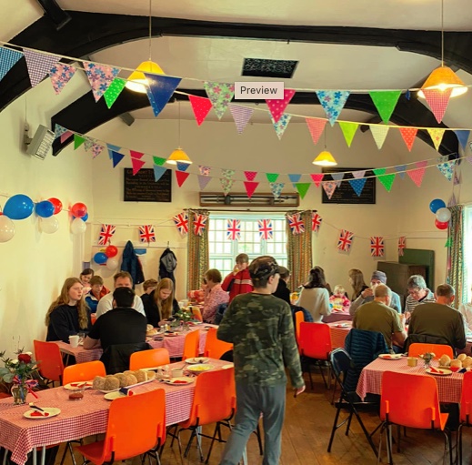 Photo of a Gosmont event in action showing people at tables and chairs in the Town Hall.