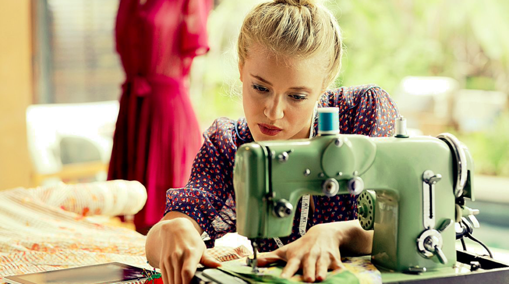 Image shows a woman using a sewing machine