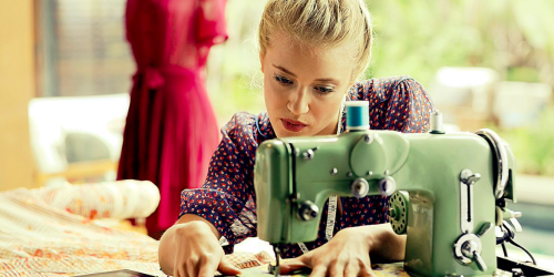 Image shows a woman using a sewing machine